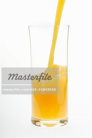 Pouring orange juice into glass