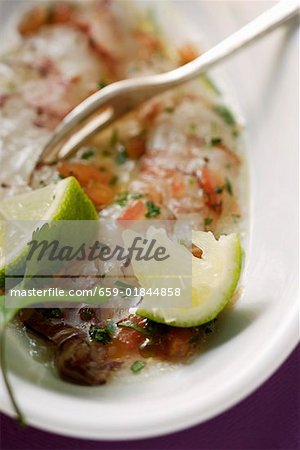Carpaccio of raw shrimps with limes and coriander leaves
