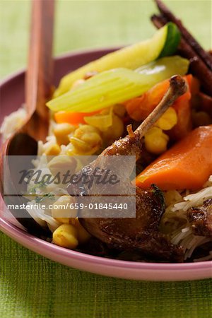 Roast pigeon with vegetables and cinnamon sticks on noodles