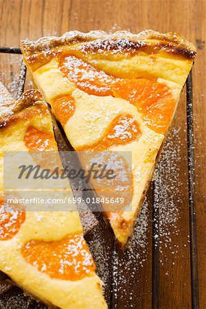 Two pieces of apricot tart with icing sugar