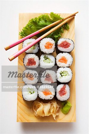 Maki sushi with fish and cucumber on sushi board