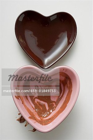 Two heart-shaped bowls, one with remains of chocolate sauce