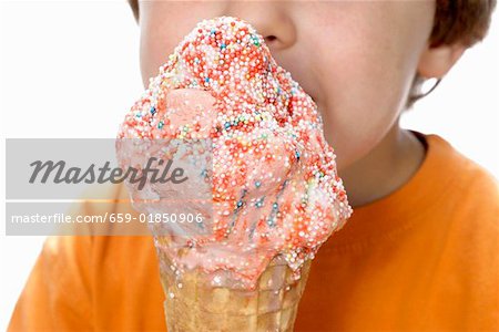 Boy holding large strawberry ice cream with coloured sprinkles