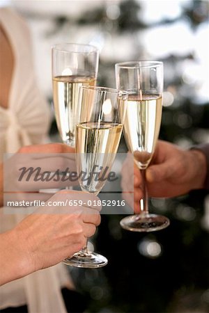 Clinking three champagne glasses