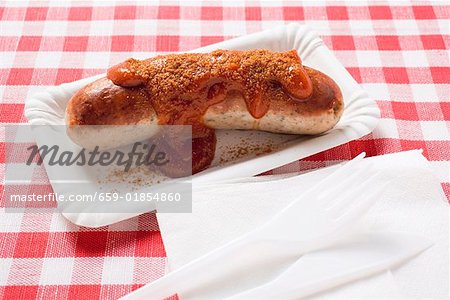 A sausage with ketchup and curry powder