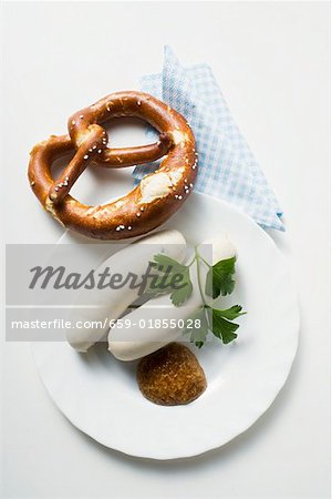 Two Weisswurst (white sausages) with pretzel and mustard