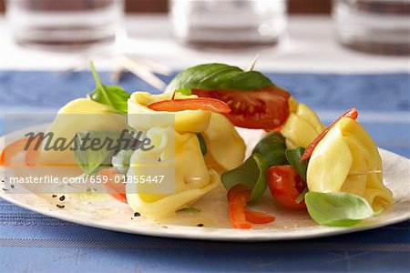 Tortellini on cocktail sticks with tomatoes and basil
