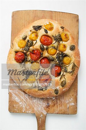 Pizza with cherry tomatoes, capers and rosemary