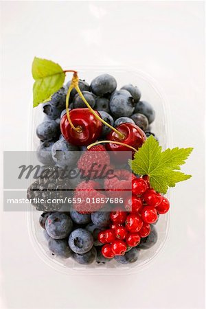 Assorted berries and two cherries in plastic punnet Assorted berries and two cherries in plastic punnet