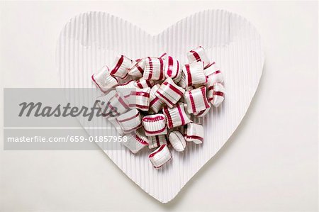 Cherry mint sweets on heart- shaped paper plate