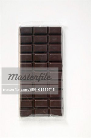 A bar of dark chocolate in cellophane