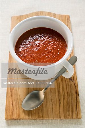 Tomato soup in cup on chopping board