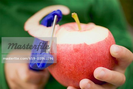 Child's hands peeling a red apple