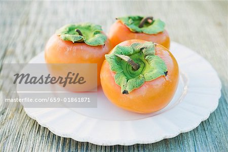 Three Sharon fruits on white plate