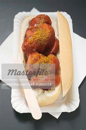 Currywurst (sausage with ketchup & curry powder) in roll in paper dish