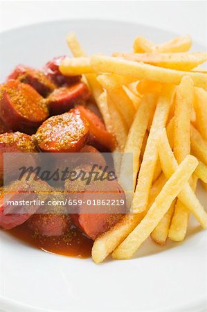 Currywurst (sausage with ketchup & curry powder) & chips on plate Currywurst (sausage with ketchup & curry powder) & chips on plate