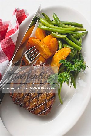 Grilled beef steak with potato wedges and green beans