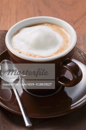 Cappuccino in brown cup and saucer