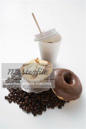 Muffin, doughnut, coffee beans and a plastic cup of coffee