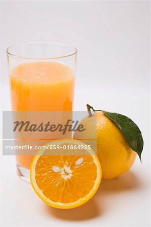 Glass of orange juice and oranges