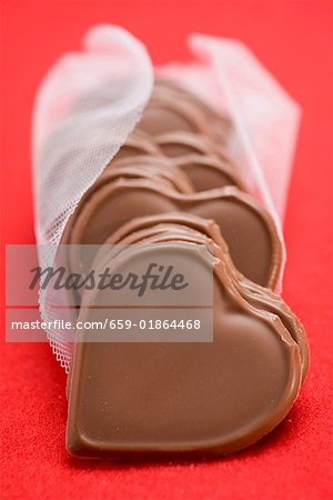 Chocolate hearts on red background