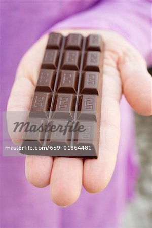 Hand holding a bar of chocolate