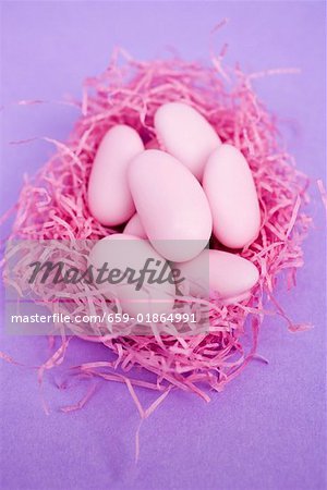 Pink sugared almonds in pink Easter grass