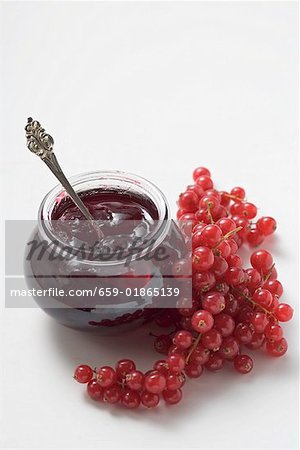 Jar of redcurrant jelly and fresh redcurrants