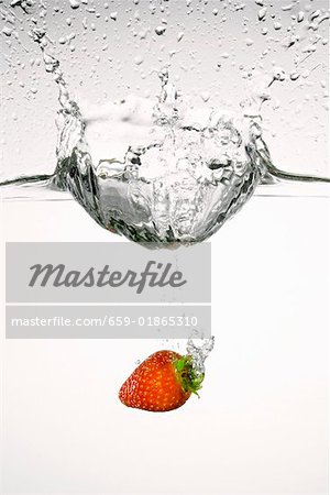 Strawberry falling into water