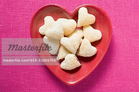 Heart-shaped jam-filled biscuits in red dish