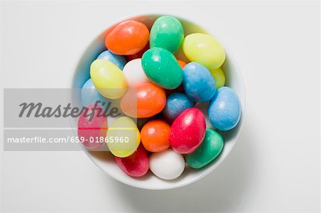 Coloured sugar eggs in white dish