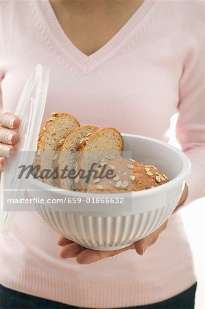 Woman holding oat bread in food storage container