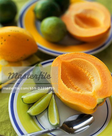 Halved papaya with lime wedges