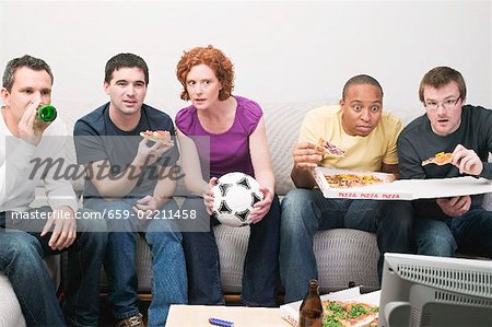 Friends with football, pizza & beer sitting in front of TV