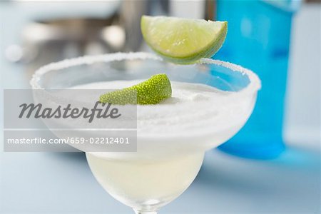 Margarita with lime wedges in a glass with a salted rim Margarita with lime wedges in a glass with a salted rim