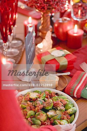 Woman serving Brussels sprouts with bacon (Christmas)