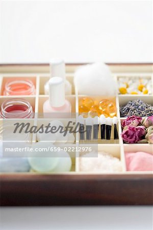Various beauty products and flowers in type case