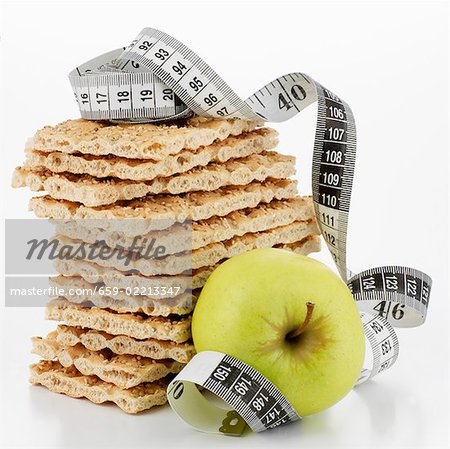 Crispbread, in a pile, and apple with tape measure