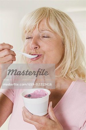 Woman eating blueberry yoghurt