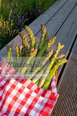 Green asparagus spears in checked cloth