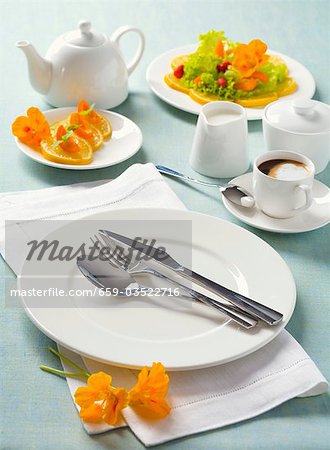 White place-setting with orange slices and coffee
