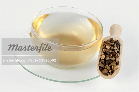 Cup of tea with dried nutgrass root in a scoop