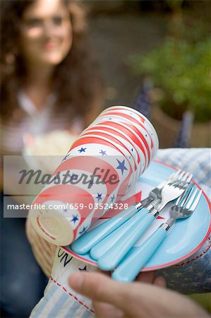 Hands holding picnic things for the 4th of July