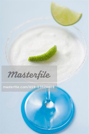 Margarita with lime wedges in a glass with a salted rim Margarita with lime wedges in a glass with a salted rim