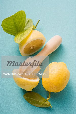 Lemons, whole, halved and squeezed, with citrus squeezer