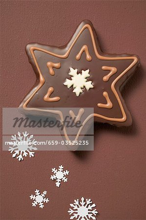 Star biscuit with chocolate icing on brown background