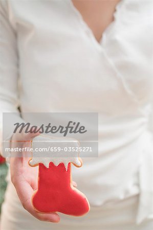 Woman holding Christmas biscuit (red boot)