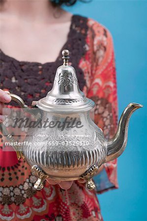 Woman holding Middle Eastern teapot