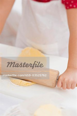 Small girl rolling out dough