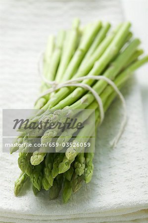 A bundle of green asparagus on white cloth